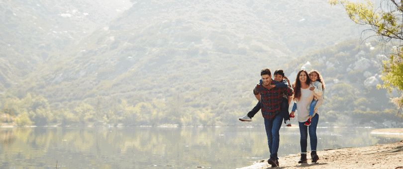 Family hiking by a lake to illustrate Signifyd's four-day workweek