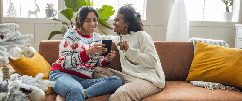 A couple on a couch doing holiday shopping online