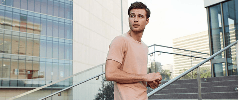 man in a Cuts shirt standing on some stairs