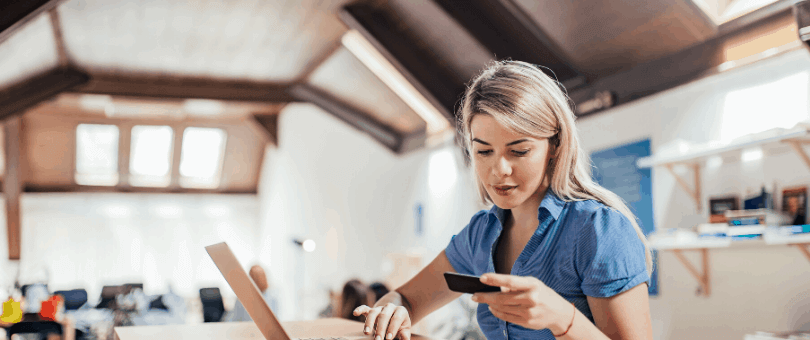 Woman online shopping at kitchen table